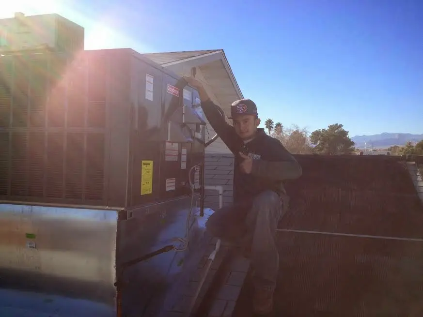 HVAC technician performing AC Tune-Up on a rooftop unit in Patterson